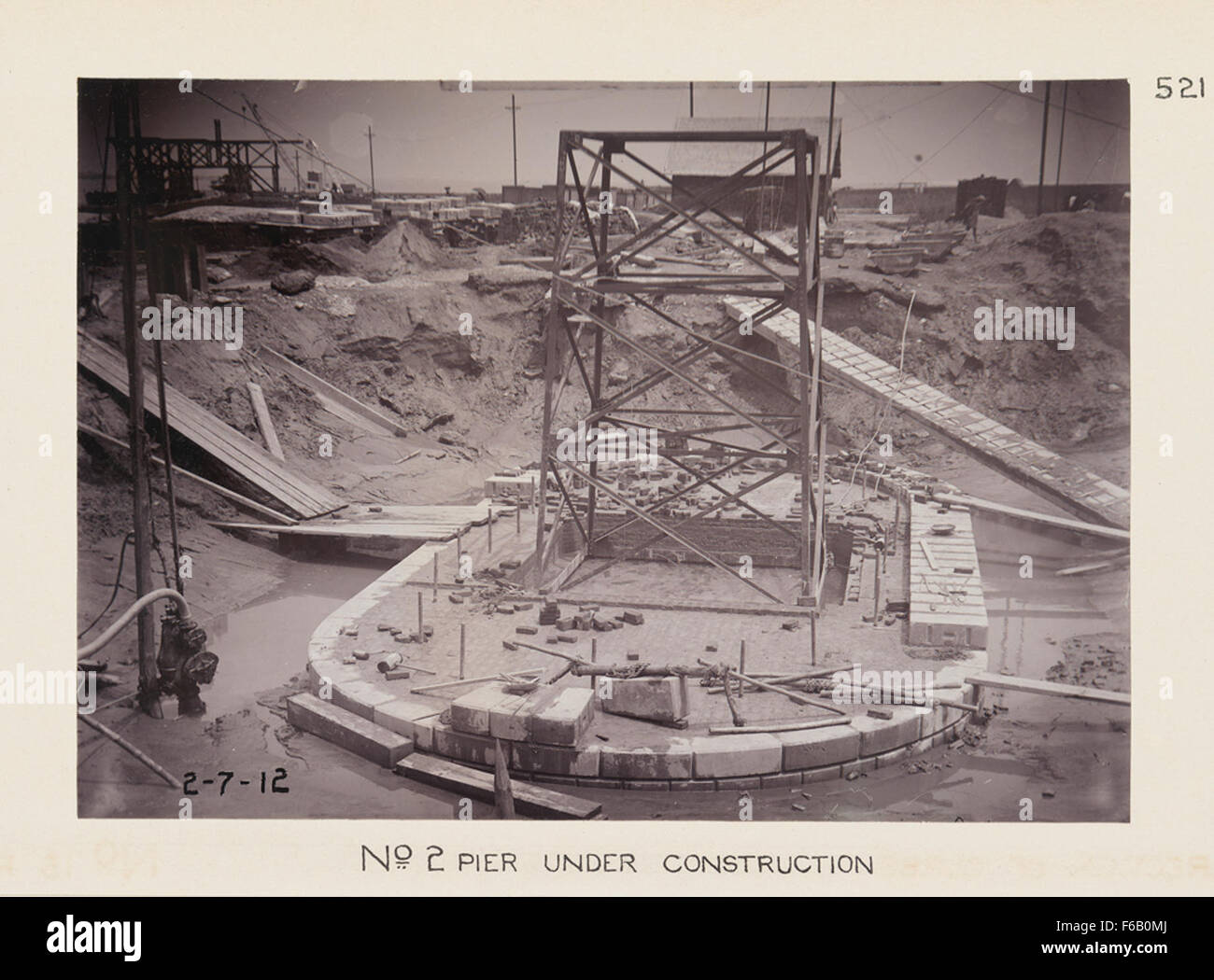 Questa fotografia mostra la costruzione del molo n. 2, un progetto infrastrutturale cruciale volto ad ampliare le strutture portuali per le moderne operazioni marittime. L'immagine raffigura le prime fasi della costruzione, con macchinari pesanti e lavoratori coinvolti. Foto Stock