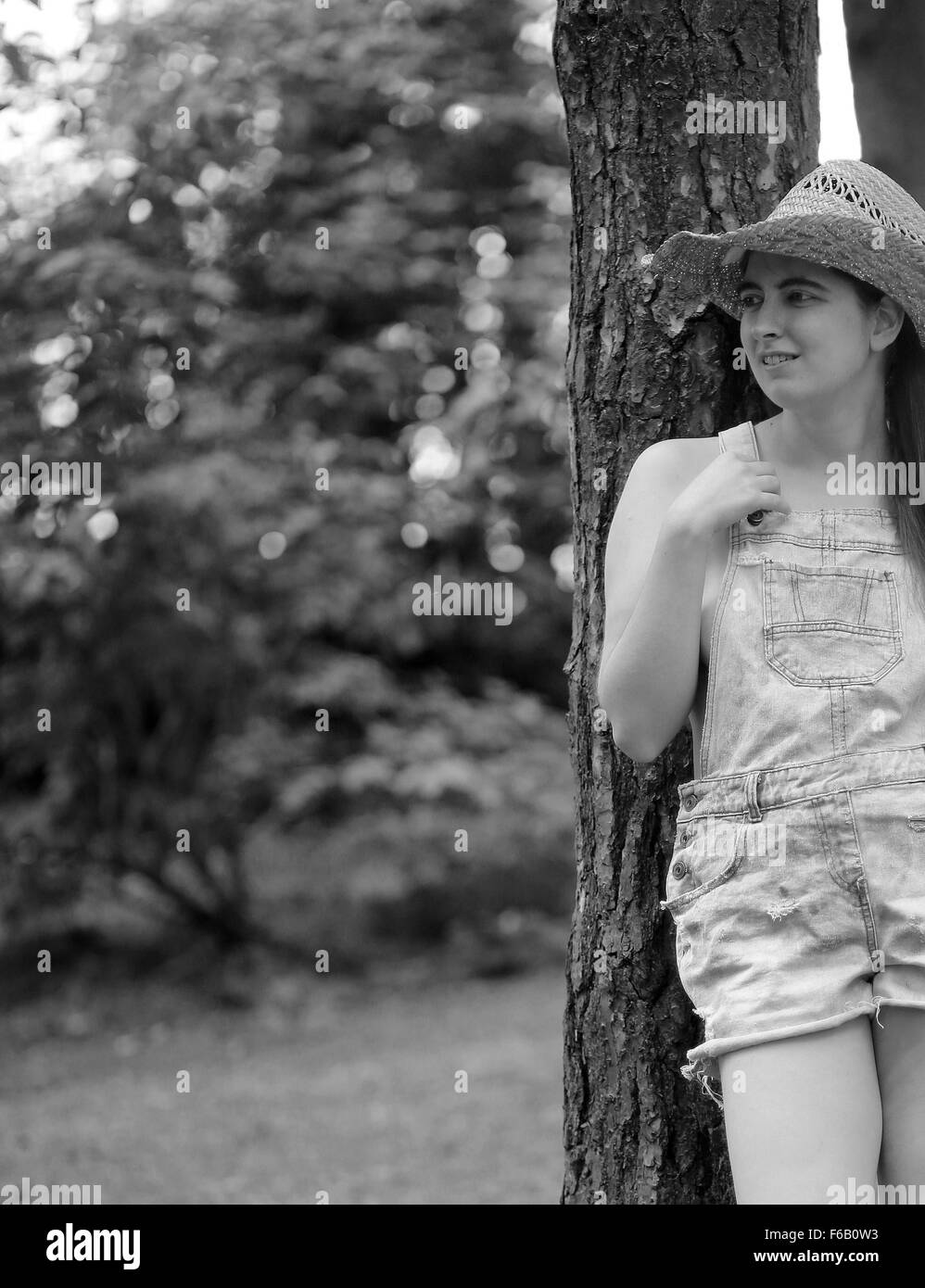 Paese tra i boschi ragazza nel vecchio dungaree tagliati corti nei boschi, Luglio 2014 Foto Stock