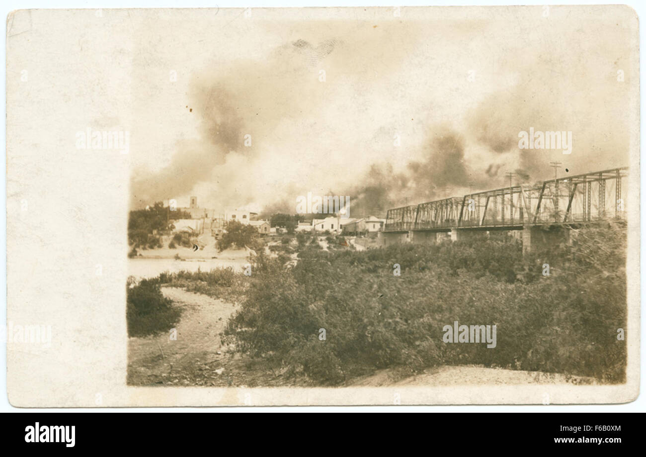 Questa fotografia storica del 24 aprile 1914 cattura la distruzione durante l'incendio di Laredo, Texas, nel contesto della rivoluzione messicana. L'immagine mostra incendi che inondano l'area, con ponti visibili attraverso il confine tra Stati Uniti e Messico. Foto Stock