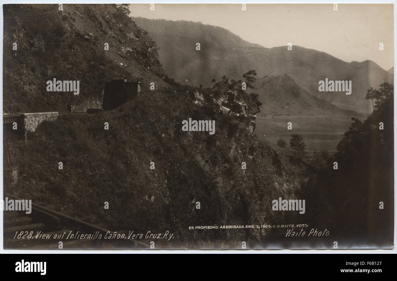 Una vista panoramica dal canone Infiernillo a Veracruz, Messico, con aspre montagne, piante e i binari ferroviari della ferrovia di Veracruz. La scena cattura la bellezza naturale del terreno e lo sviluppo dell'infrastruttura ferroviaria. Foto Stock