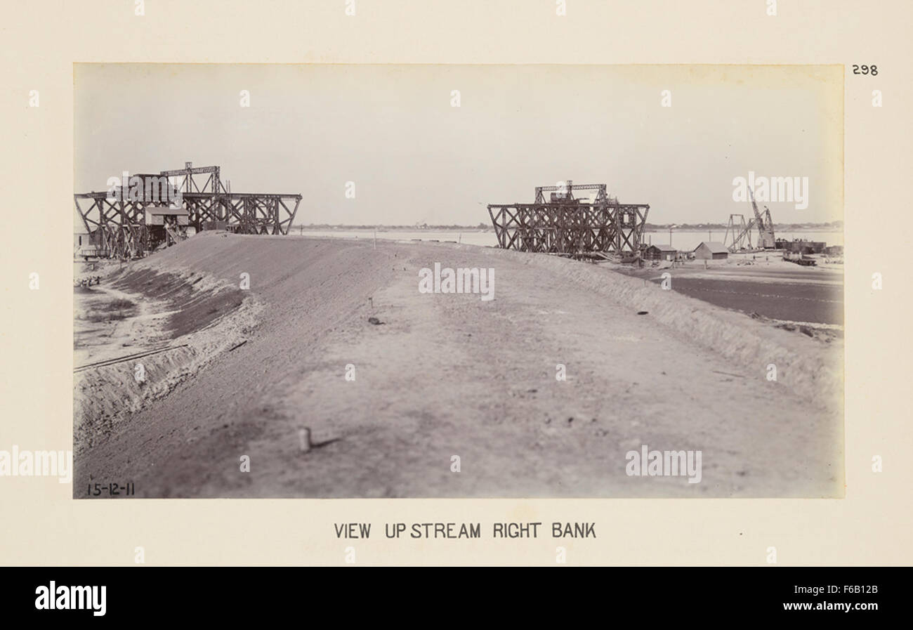 Questa immagine presenta una vista della costruzione del ponte sulla riva destra di un fiume, con l'attenzione sui ponti ferroviari. La scena evidenzia gli sforzi ingegneristici e di costruzione nella costruzione del ponte che facilita il trasporto attraverso il canale. Foto Stock