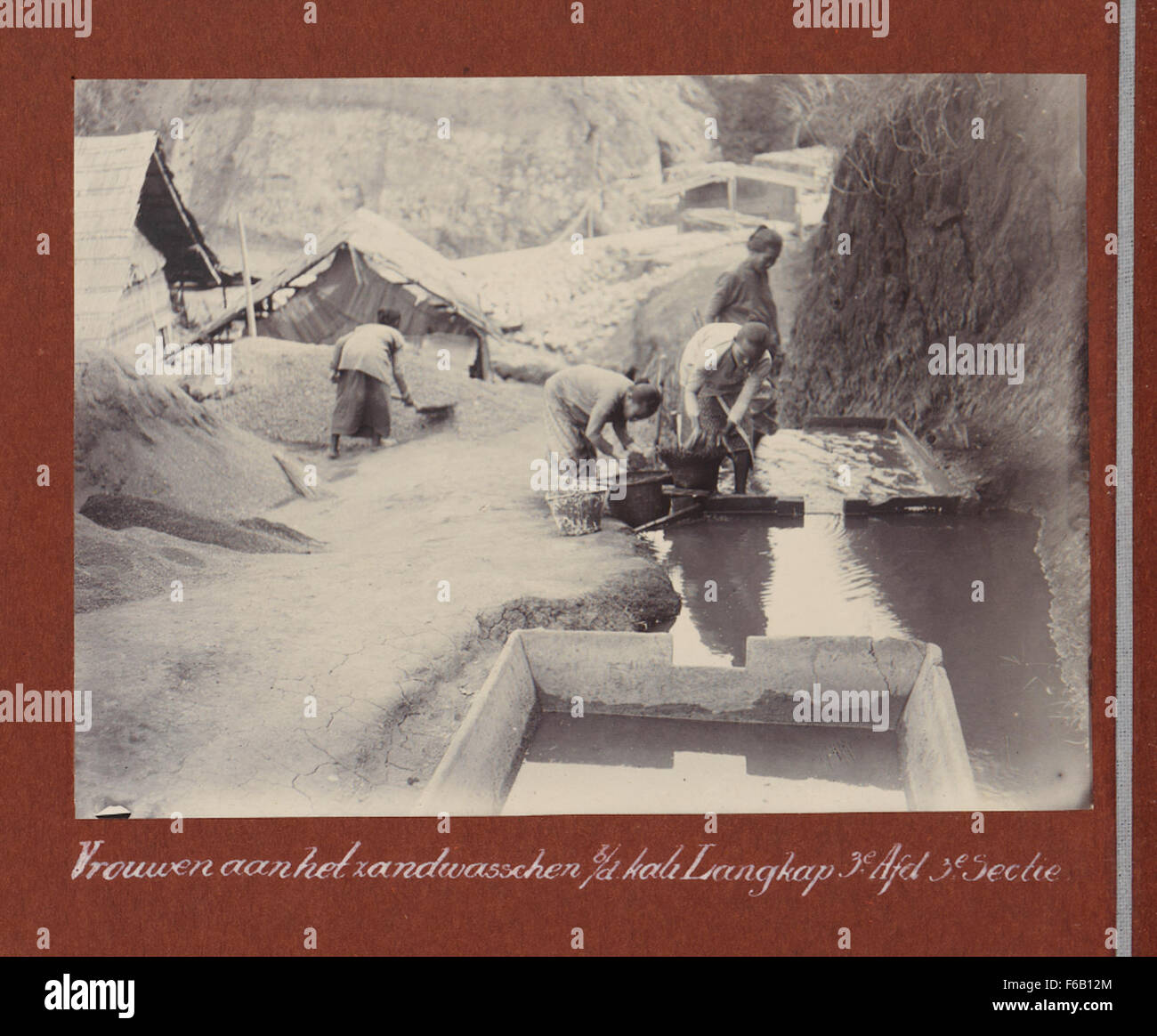 Questa immagine mostra le donne che lavano la sabbia sul fiume Kali Langkap, vicino a un cantiere per la ferrovia Staatsspoorwegen nelle Indie Orientali olandesi. Il lavoro delle donne ha contribuito alla costruzione di infrastrutture durante il periodo coloniale, evidenziando il loro ruolo nei primi progetti industriali. Foto Stock