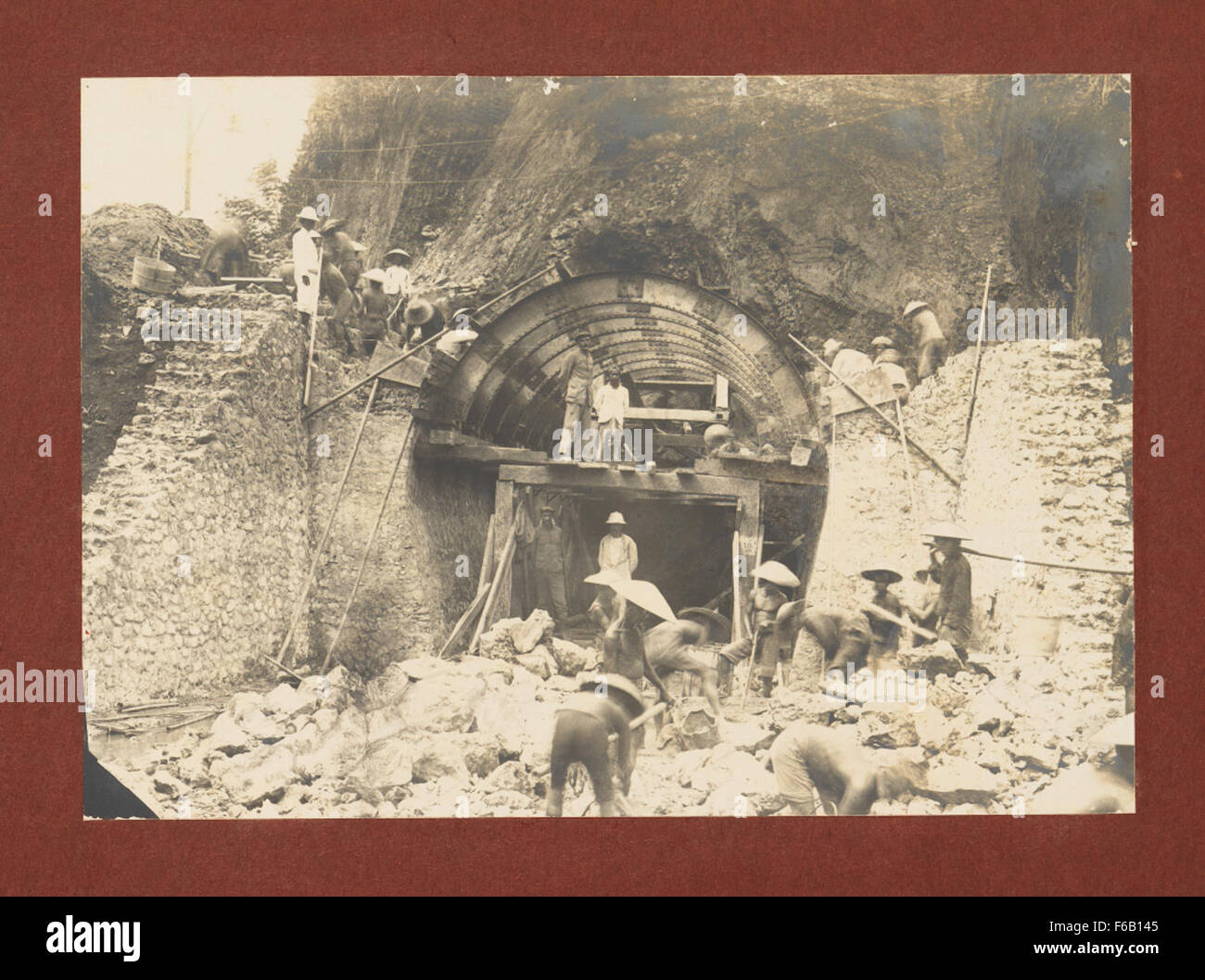 Questa immagine cattura lo scavo e la costruzione di un tunnel ferroviario tra Cirebon e Kroya, concentrandosi sui lavoratori e sui loro sforzi nella costruzione delle infrastrutture per il sistema ferroviario statale. Foto Stock