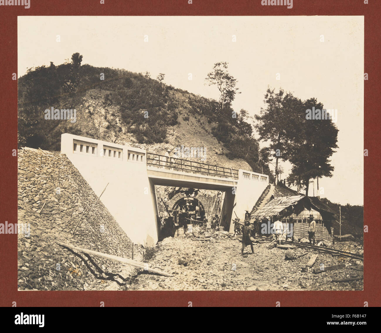 Questa fotografia storica cattura i lavoratori in azione durante gli scavi e la costruzione del tunnel della linea ferroviaria Cirebon-Kroya. L'immagine mette in evidenza la prima ingegneria ferroviaria, il lavoro manuale e la scala monumentale dell'infrastruttura. Foto Stock