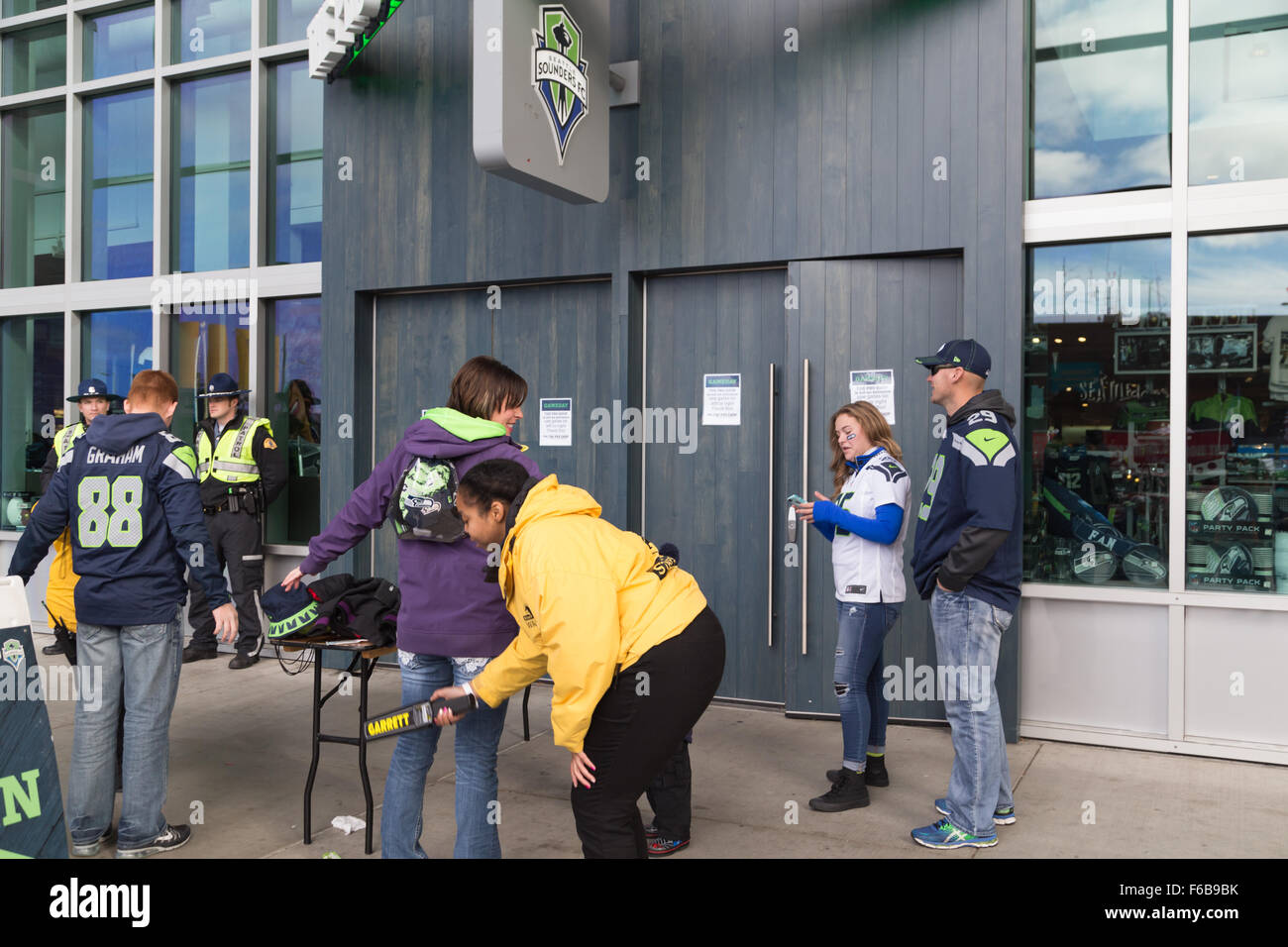 Seattle, Stati Uniti d'America. 15th. Novembre, 2015. Conseguenze del terrorismo a Parigi, Francia, i clienti per il Centurylink stadium sport shop vengono scansionati da stadium il personale addetto alla sicurezza in presenza della Pattuglia sate. Credito: Maria S../Alamy Live News Foto Stock