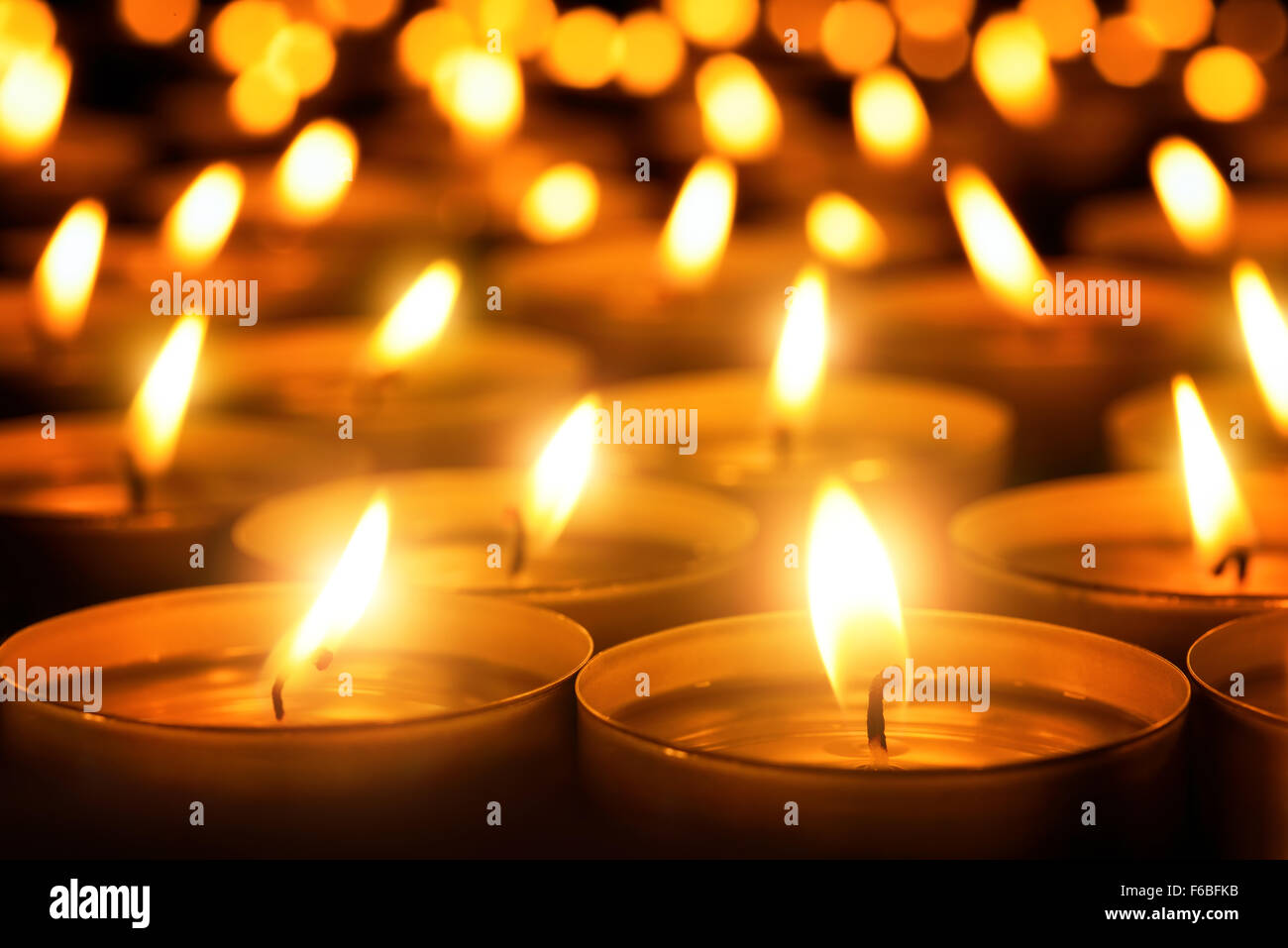 Molte fiamme di candela incandescente al buio, crea un atmosfera spirituale Foto Stock