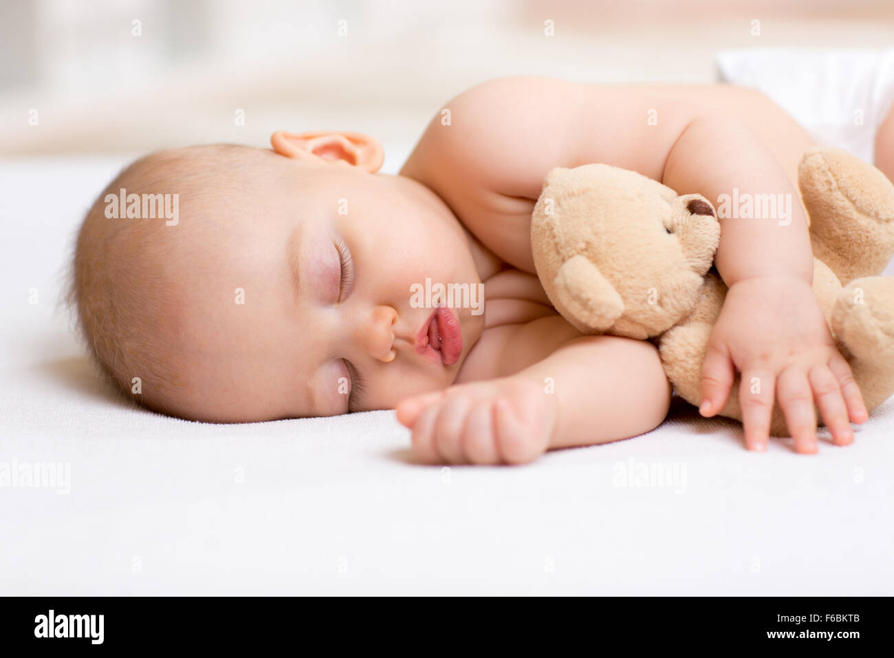 Spensierato dormire bambino con il giocattolo morbido Foto Stock