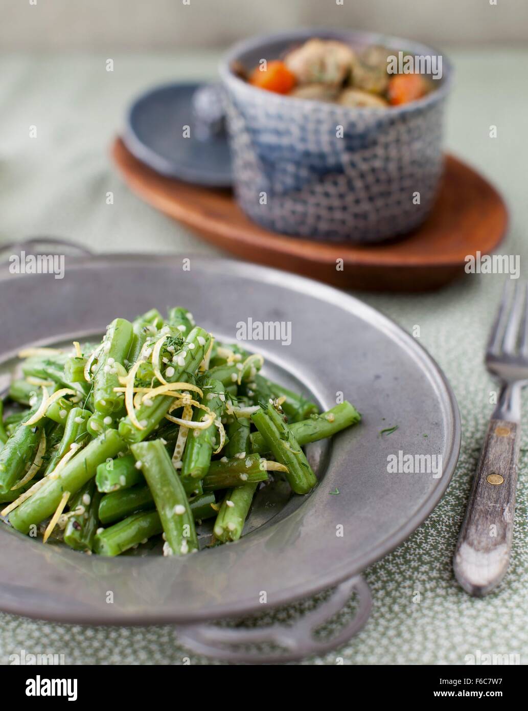 Verde Insalata di fagioli con una ciotola di salsa speziata Turchia stufare in background Foto Stock