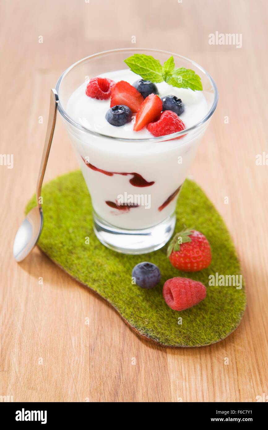 Yogurt con vari frutti di bosco in un bicchiere Foto Stock