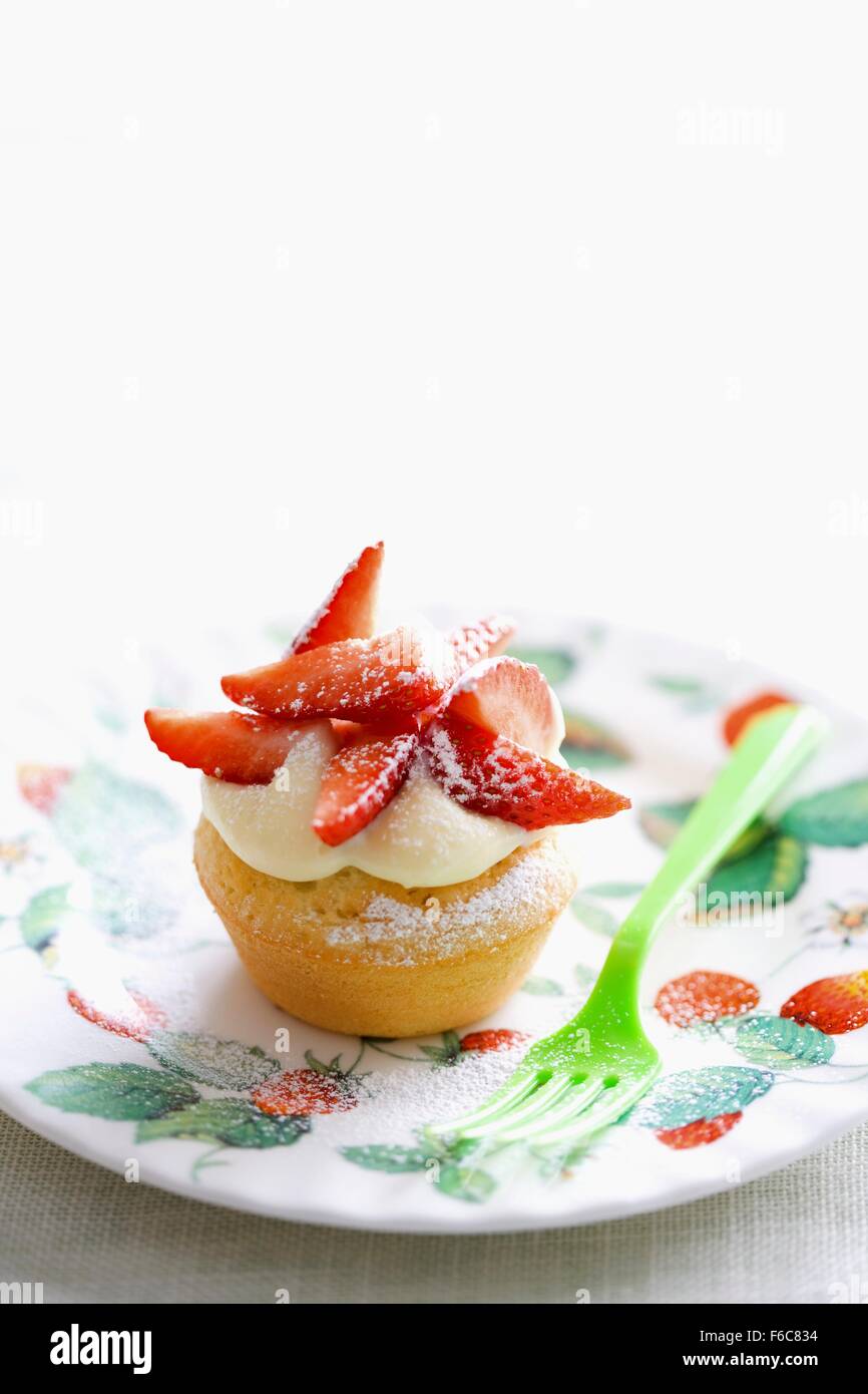 Una tortina guarnita con il cioccolato bianco panna e fragole Foto Stock