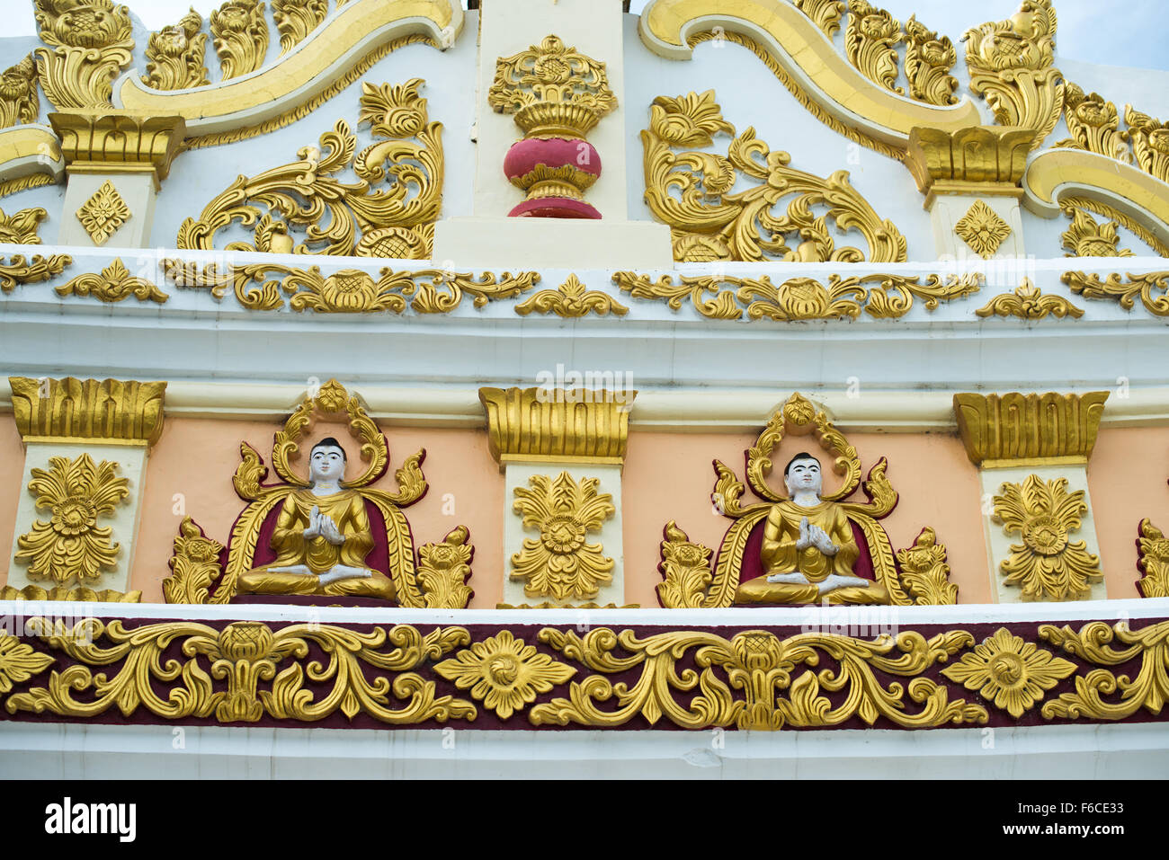 U min Thonze Pagoda Arches Sagaing Myanmar // SAGAING, Myanmar — ornamenti decorativi ornati ornano gli archi esterni della Pagoda U min Thonze (nota anche come Pagoda OoHminThoneSel), un caratteristico monumento buddista costruito sulla collina di Sagaing. La pagoda presenta un colonnato a forma di mezzaluna che ospita 45 statue di Buddha, con il suo nome che si traduce in "Pagoda delle trenta grotte" in riferimento ai suoi 30 archi d'ingresso decorati. Originariamente fondata dal re Tarabya i tra il 1327 e il 1335, l'attuale struttura risale principalmente al 1847 dopo la ricostruzione dopo il devastante terremoto di Ava del 1839. Il sito ha meno di Foto Stock