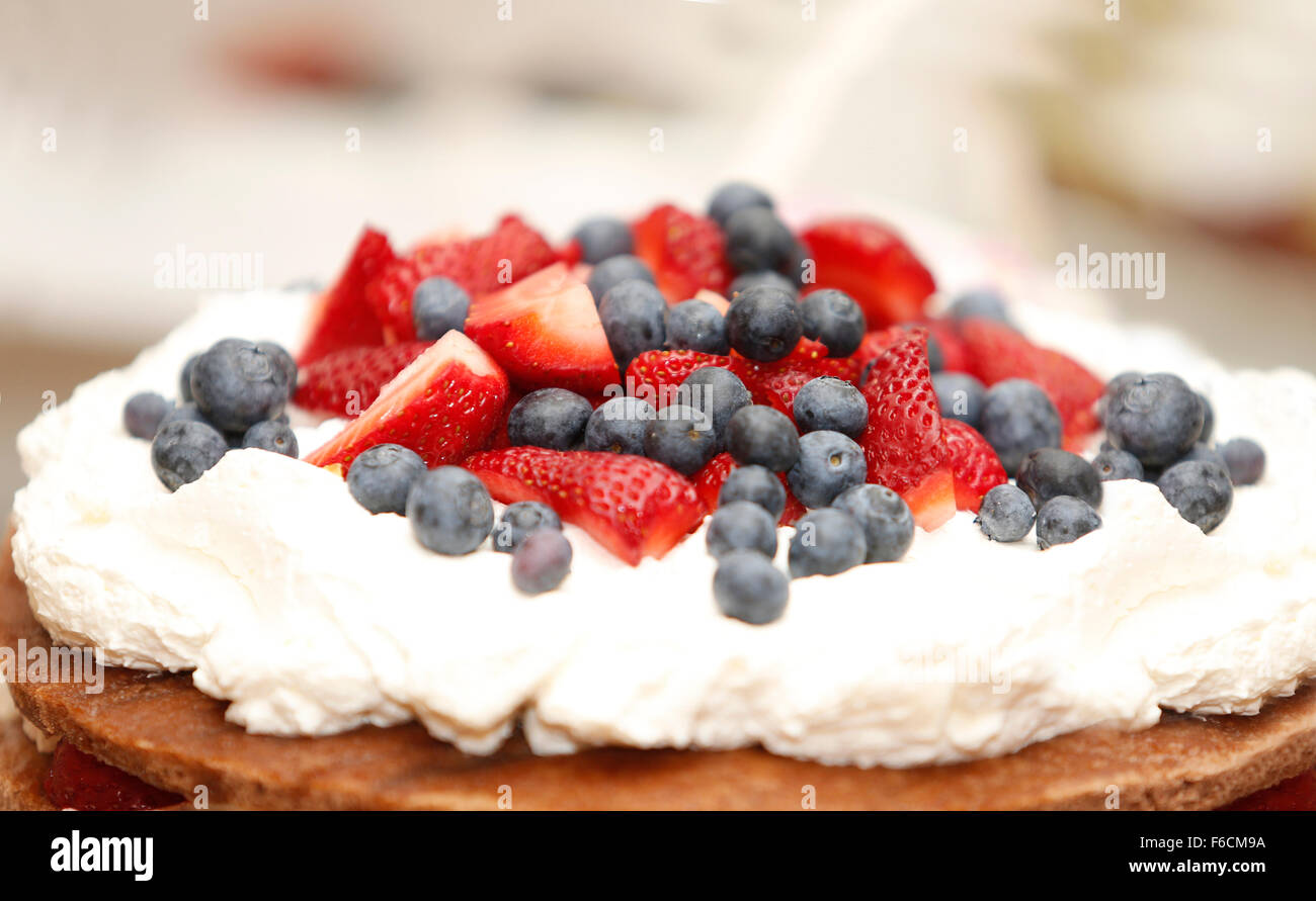 La deliziosa torta di biscotti con le fragole e i mirtilli sulla tavola di dolci per la festa di nozze Foto Stock