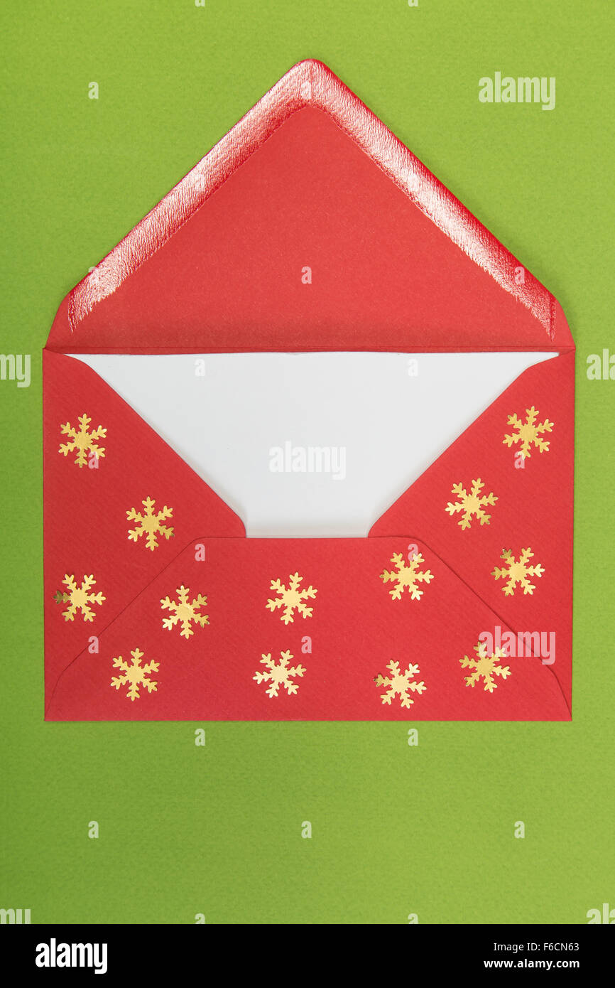 Aperta la busta rossa e fiocchi di neve su sfondo verde, Natale Foto Stock