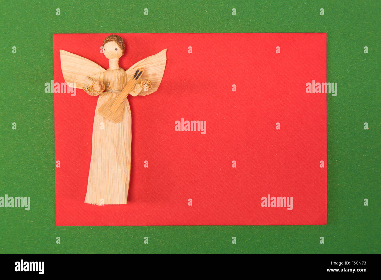 Scheda di natale con angelo e su sfondo verde Foto Stock