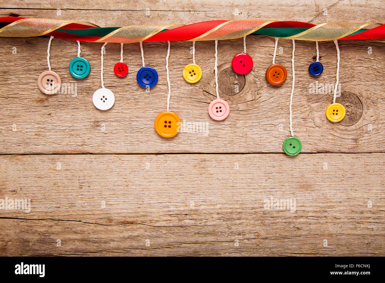 Natale biglietto di auguri, appeso pulsanti colorati su sfondo di legno Foto Stock