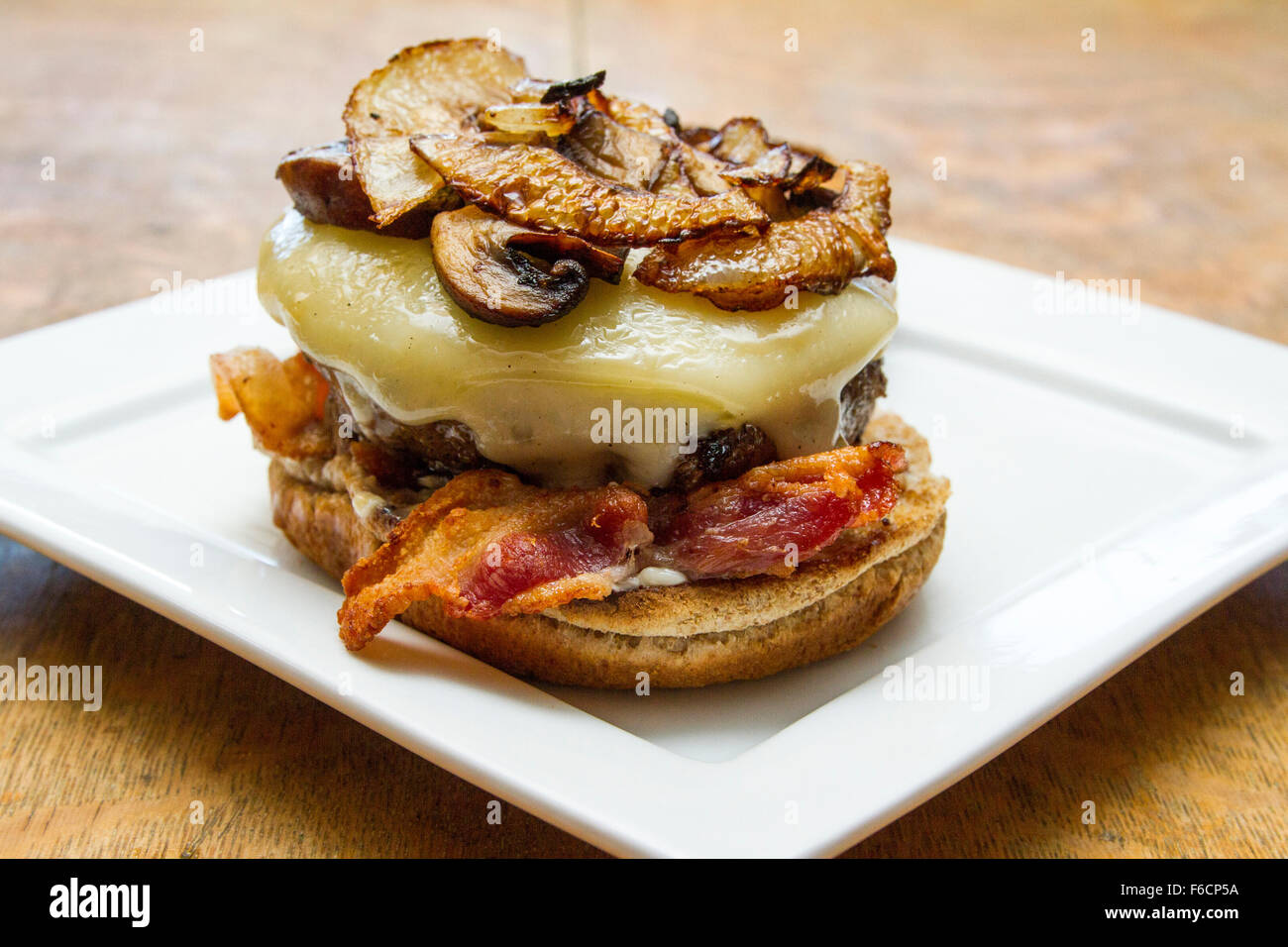 Un fungo, svizzero, la pancetta, il soffritto di cipolla, hamburger su un intero tostato bun di frumento Foto Stock