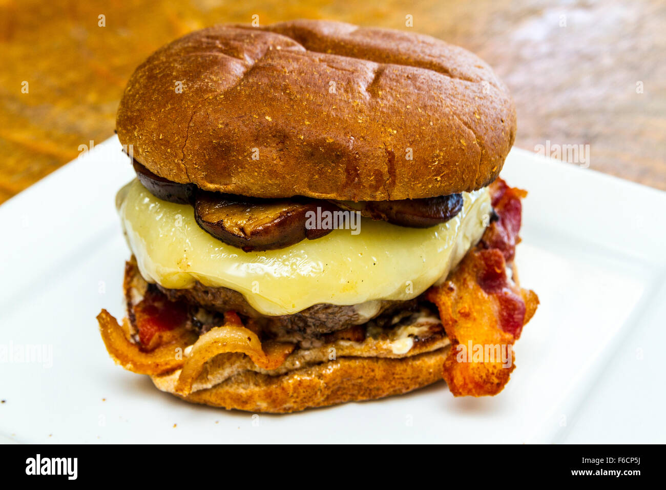 Un fungo, svizzero, la pancetta, il soffritto di cipolla, hamburger su un intero tostato bun di frumento Foto Stock