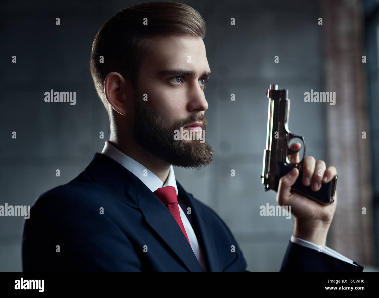 Pericolo l uomo con la pistola cercando riposo verticale. Foto Stock