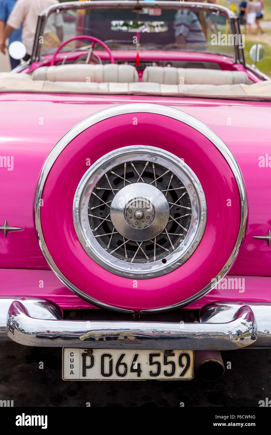 La ruota di scorta, scarico, ruote a raggi, rosa taxi cabriolet convertibile, classic car nelle strade, old American road cruiser Foto Stock