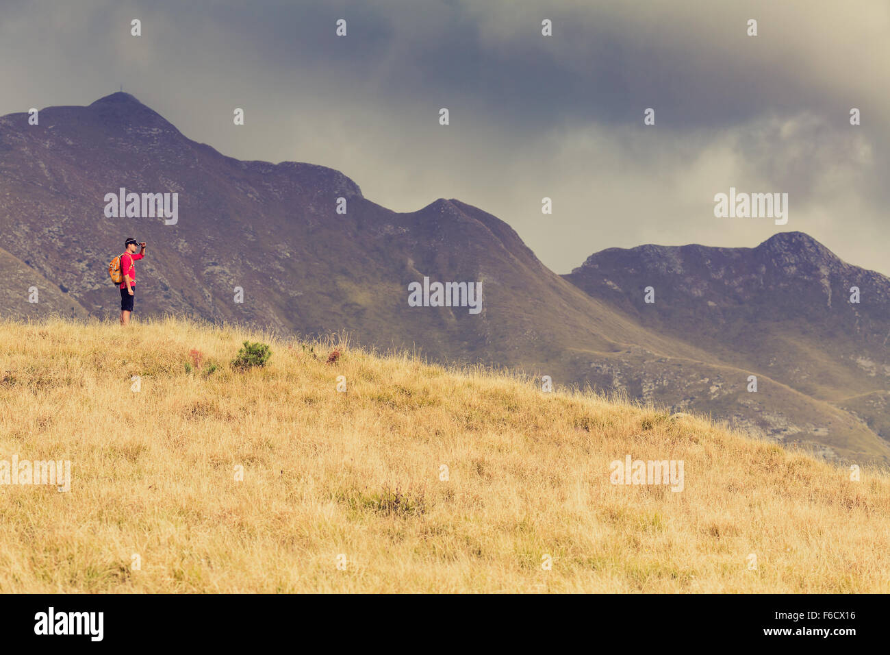 Escursionismo uomo o un sentiero a piedi di runner e guardando a vista montagne. Viaggiare in Italia, l'Europa. Fitness e uno stile di vita sano per esterno Foto Stock
