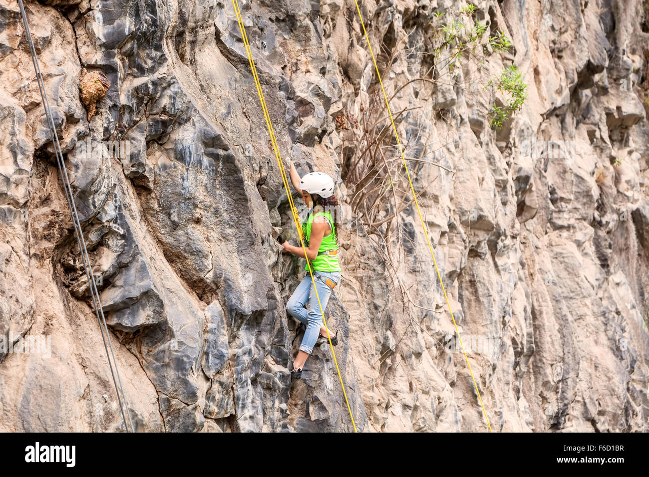 Banos, Ecuador - 30 Novembre 2014: la sfida di basalto del Tungurahua, bambina indossa Arrampicata attrezzature è Arrampicata su una roccia Foto Stock