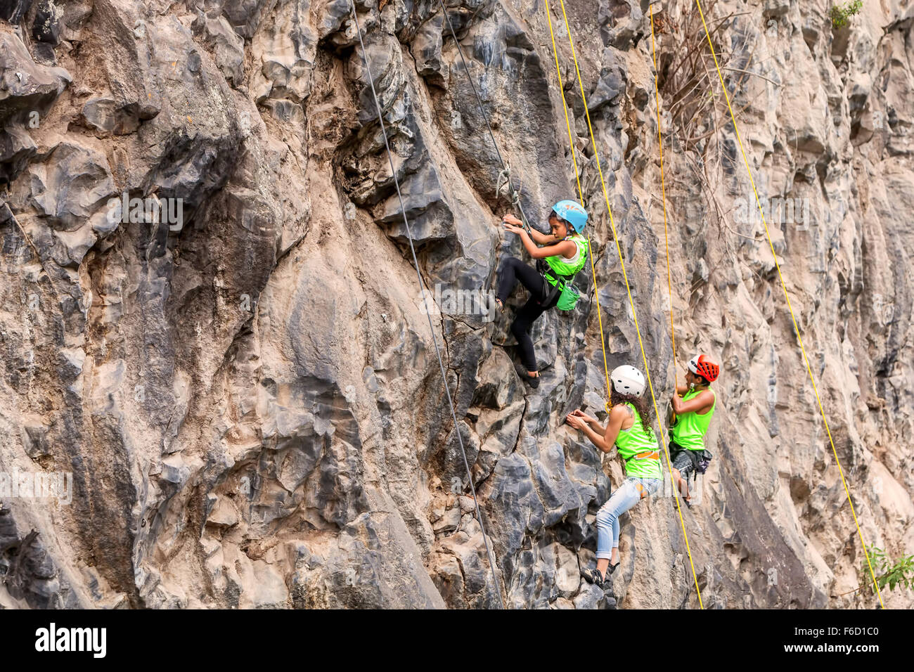 Banos, Ecuador - 30 Novembre 2014: la sfida di basalto del Tungurahua, giovane gruppo di Alpinisti scalare una parete di roccia in Banos Foto Stock