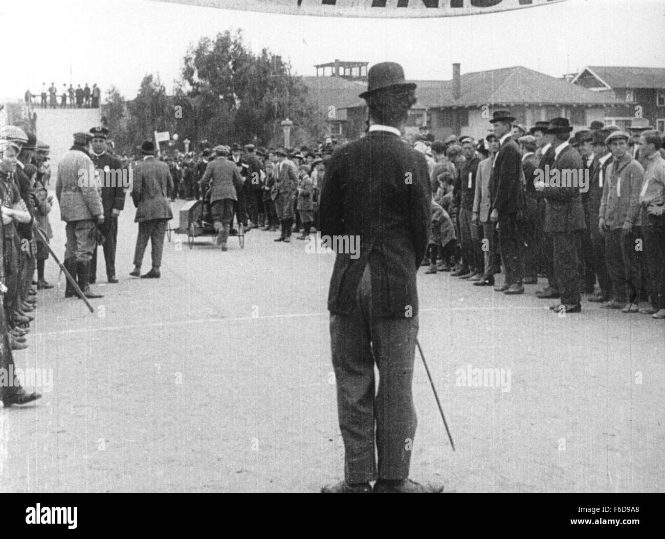 Data di rilascio: febbraio 7,1914. Il titolo del filmato: Capretto gare di auto a Venezia. STUDIO: Keystone Film Company. Trama: Charlie, vestito come un barbone per la prima volta, va a un baby-carrello gara in Venice, California. Egli provoca una grande quantità di problemi e confusione, sia su off la via (di intralcio al cameraman) e su (interferendo con la gara). Egli riesce a irritante entrambi i partecipanti ed il pubblico. Nella foto: Charles Chaplin come barbone. Foto Stock