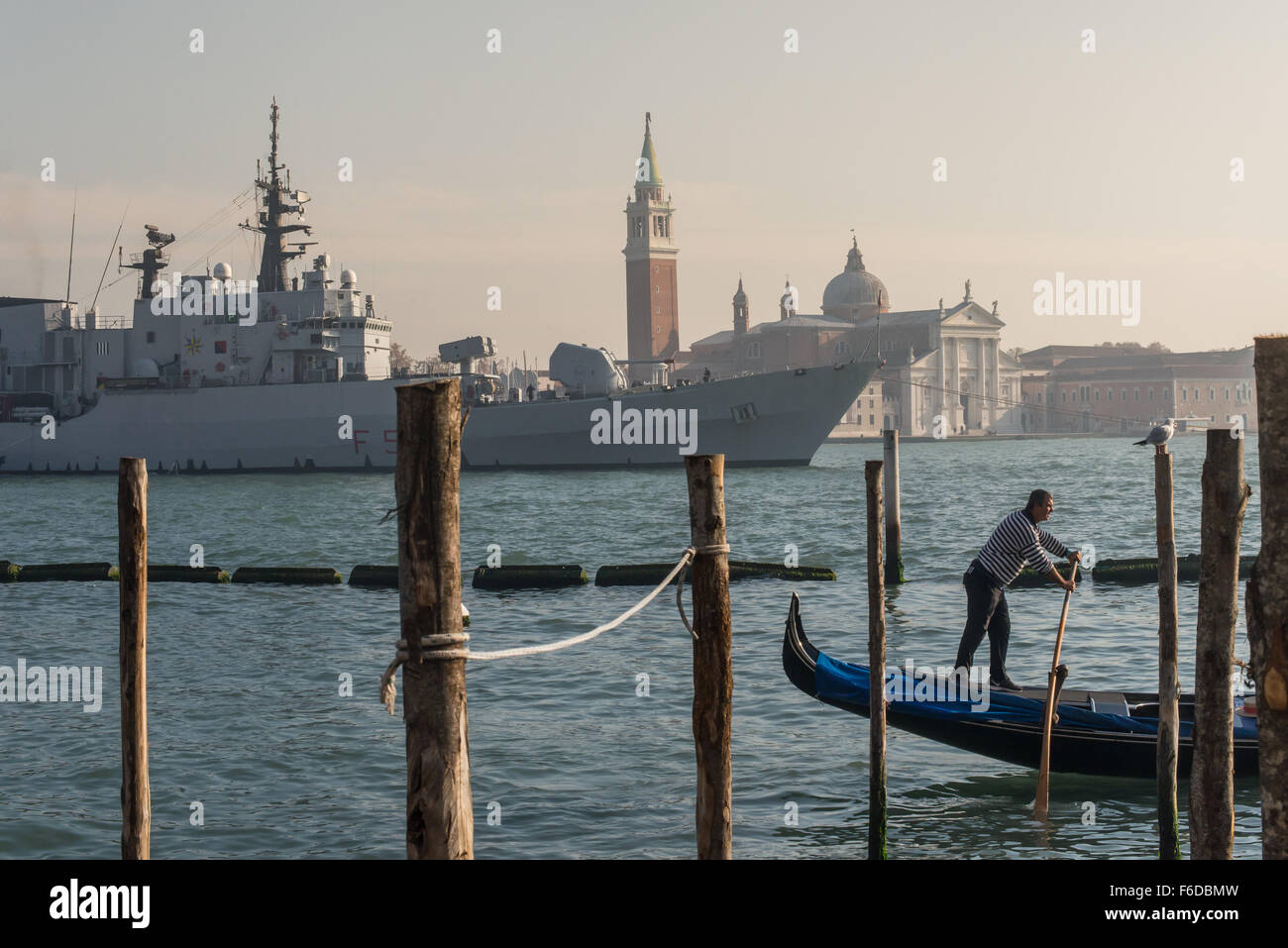 Venezia, Italia - 10 novembre 2015 - di una nave da guerra nella Venezia canalgrande incorniciata da un gondoliere in primo piano Foto Stock