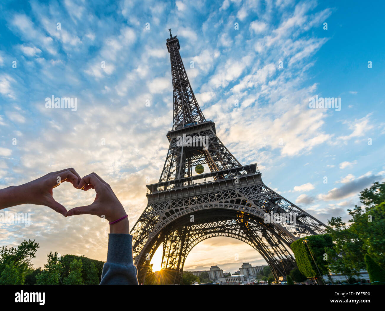 Mani formando il cuore, tramonto dietro la torre Eiffel di Parigi e dell' Ile-de-France, Francia Foto Stock