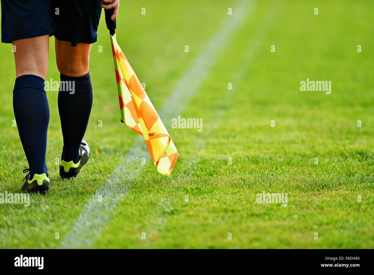 Arbitro assistente in movimento lungo il diversivo durante una partita di calcio Foto Stock