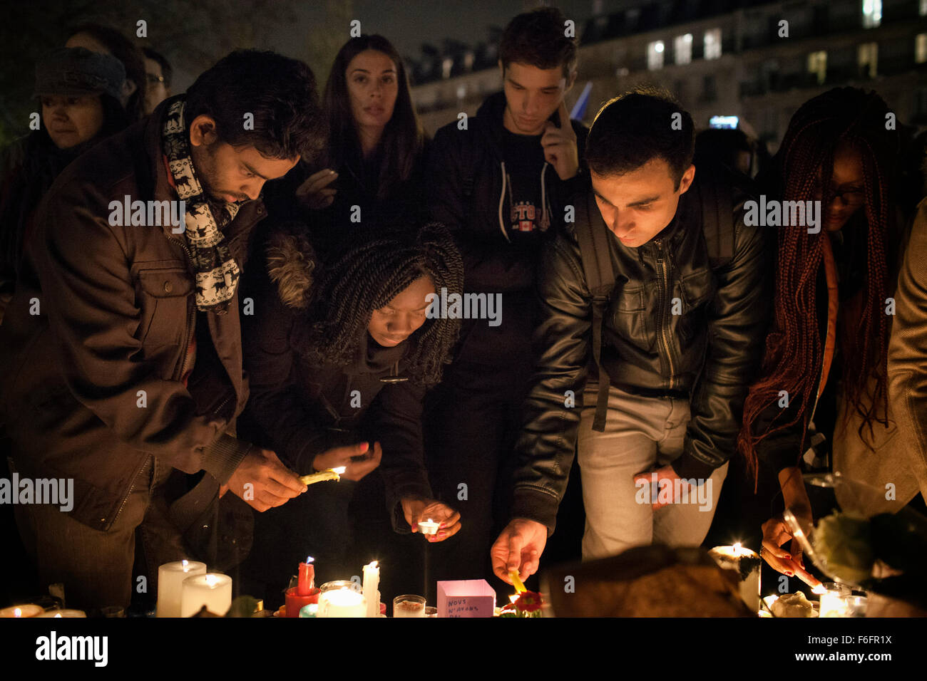 Parigi, Francia. 16 Novembre, 2015. Persone in lutto accendono le candele e fiore di laici in memoria delle vittime. In seguito il 13 novembre attacchi terroristici, place de la Republique, (Piazza della Repubblica) è diventato un ripiego memoriale per le vittime. In una serie di atti di violenza, circa 129 persone sono state uccidendo in sparatorie e attentato suicida. ISIL o stato islamico ha rivendicato la responsabilità. Credito: Leo romanzo/Alamy Live News Foto Stock