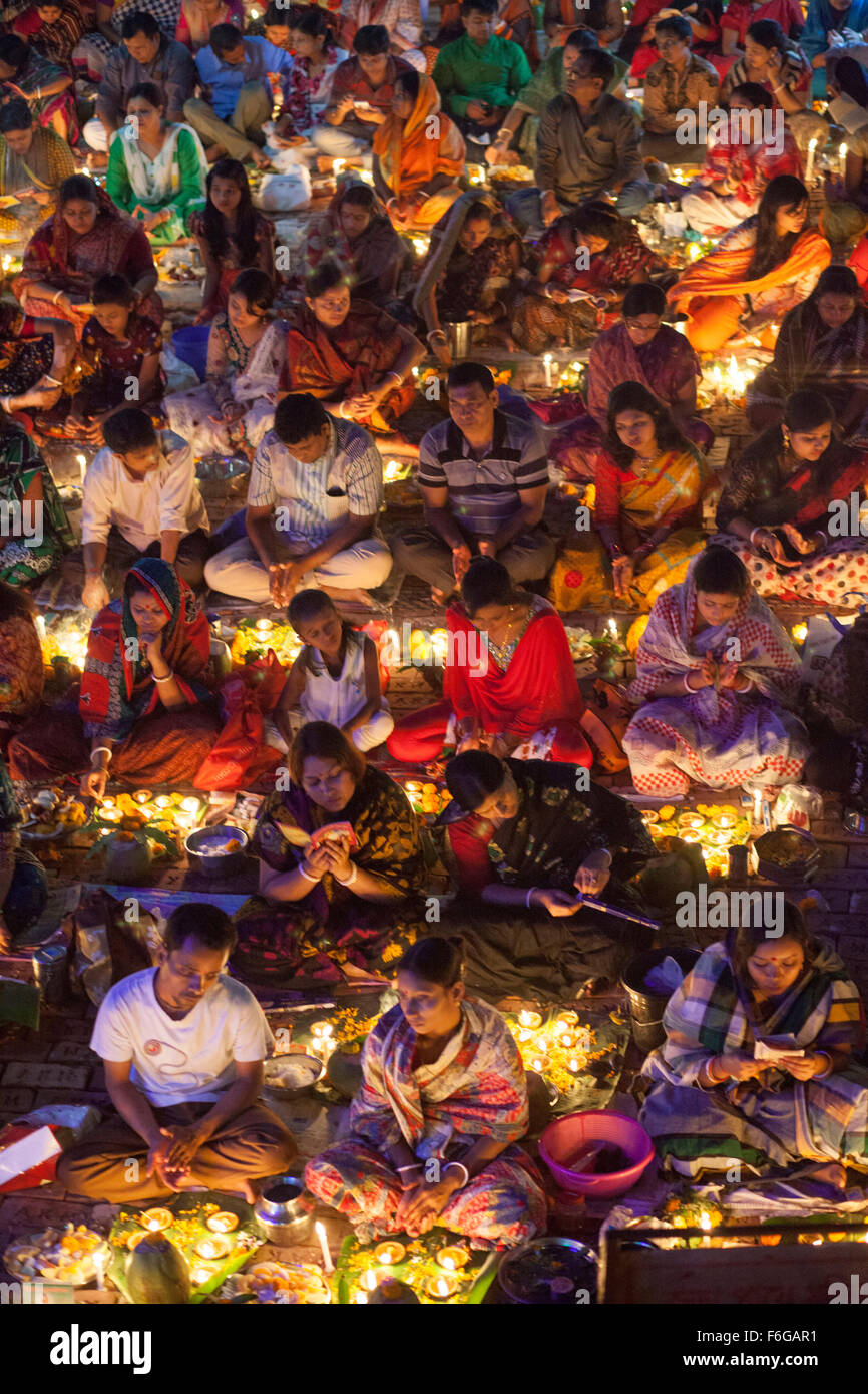 Dacca in Bangladesh. 17 Nov 2015. Migliaia di devoti indù si siede con Prodip e prega Dio di fronte Shri Shri Lokanath Brahmachari Ashram tempio durante il Kartik Brati o Rakher Upobash Dhaka il 17 novembre 2015. Ogni anno migliaia di devoti indù si riuniscono di fronte di Shri Shri Lokenath Brahmachari Ashram tempio per il Kartik Brati o Rakher Upobash festival religioso in Barodi, vicino a Dacca in Bangladesh. Fedeli di sedersi di fronte luce delle candele ( chiamato localmente come Prodip ) e assorbire nella preghiera...Lokenath Brahmachari chi è chiamato Baba Lokenath era un 18t Foto Stock