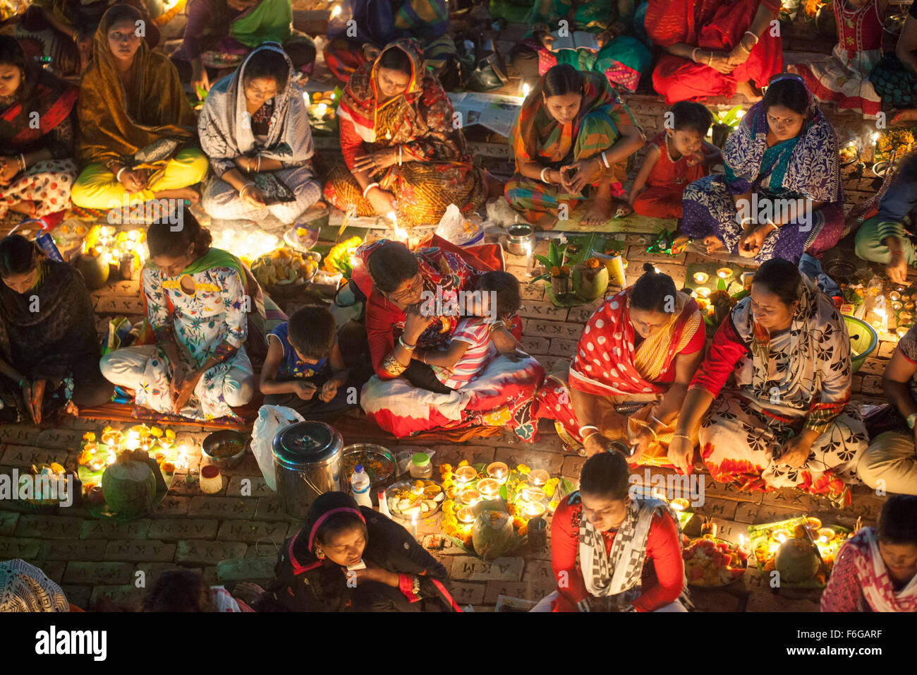 Dacca in Bangladesh. 17 Nov 2015. Migliaia di devoti indù si siede con Prodip e prega Dio di fronte Shri Shri Lokanath Brahmachari Ashram tempio durante il Kartik Brati o Rakher Upobash Dhaka il 17 novembre 2015. Ogni anno migliaia di devoti indù si riuniscono di fronte di Shri Shri Lokenath Brahmachari Ashram tempio per il Kartik Brati o Rakher Upobash festival religioso in Barodi, vicino a Dacca in Bangladesh. Fedeli di sedersi di fronte luce delle candele ( chiamato localmente come Prodip ) e assorbire nella preghiera...Lokenath Brahmachari chi è chiamato Baba Lokenath era un 18t Foto Stock