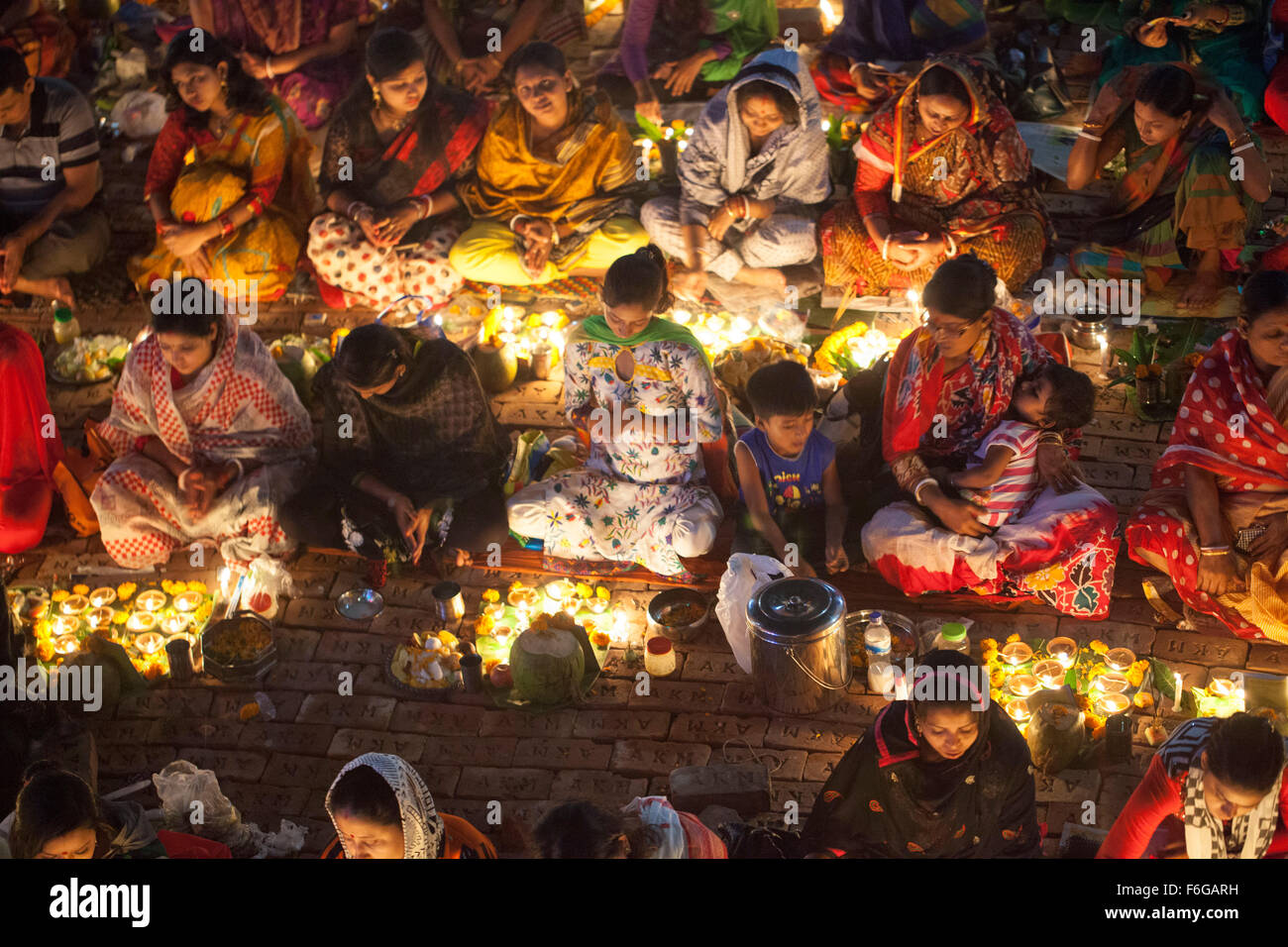 Dacca in Bangladesh. 17 Nov 2015. Migliaia di devoti indù si siede con Prodip e prega Dio di fronte Shri Shri Lokanath Brahmachari Ashram tempio durante il Kartik Brati o Rakher Upobash Dhaka il 17 novembre 2015. Ogni anno migliaia di devoti indù si riuniscono di fronte di Shri Shri Lokenath Brahmachari Ashram tempio per il Kartik Brati o Rakher Upobash festival religioso in Barodi, vicino a Dacca in Bangladesh. Fedeli di sedersi di fronte luce delle candele ( chiamato localmente come Prodip ) e assorbire nella preghiera...Lokenath Brahmachari chi è chiamato Baba Lokenath era un 18t Foto Stock