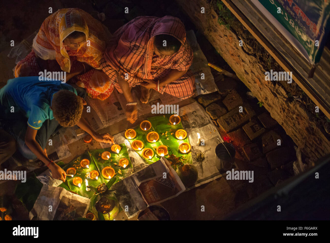 Dacca in Bangladesh. 17 Nov 2015. Migliaia di devoti indù si siede con Prodip e prega Dio di fronte Shri Shri Lokanath Brahmachari Ashram tempio durante il Kartik Brati o Rakher Upobash Dhaka il 17 novembre 2015. Ogni anno migliaia di devoti indù si riuniscono di fronte di Shri Shri Lokenath Brahmachari Ashram tempio per il Kartik Brati o Rakher Upobash festival religioso in Barodi, vicino a Dacca in Bangladesh. Fedeli di sedersi di fronte luce delle candele ( chiamato localmente come Prodip ) e assorbire nella preghiera...Lokenath Brahmachari chi è chiamato Baba Lokenath era un 18t Foto Stock