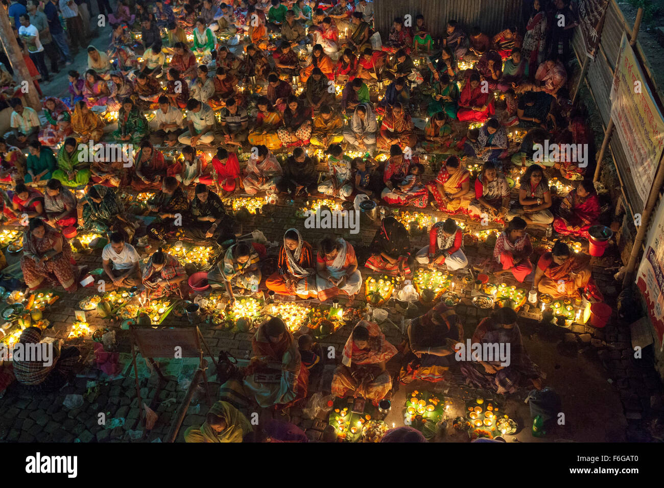 Dacca in Bangladesh. 17 Nov 2015. Migliaia di devoti indù si siede con Prodip e prega Dio di fronte Shri Shri Lokanath Brahmachari Ashram tempio durante il Kartik Brati o Rakher Upobash Dhaka il 17 novembre 2015. Ogni anno migliaia di devoti indù si riuniscono di fronte di Shri Shri Lokenath Brahmachari Ashram tempio per il Kartik Brati o Rakher Upobash festival religioso in Barodi, vicino a Dacca in Bangladesh. Fedeli di sedersi di fronte luce delle candele ( chiamato localmente come Prodip ) e assorbire nella preghiera...Lokenath Brahmachari chi è chiamato Baba Lokenath era un 18t Foto Stock