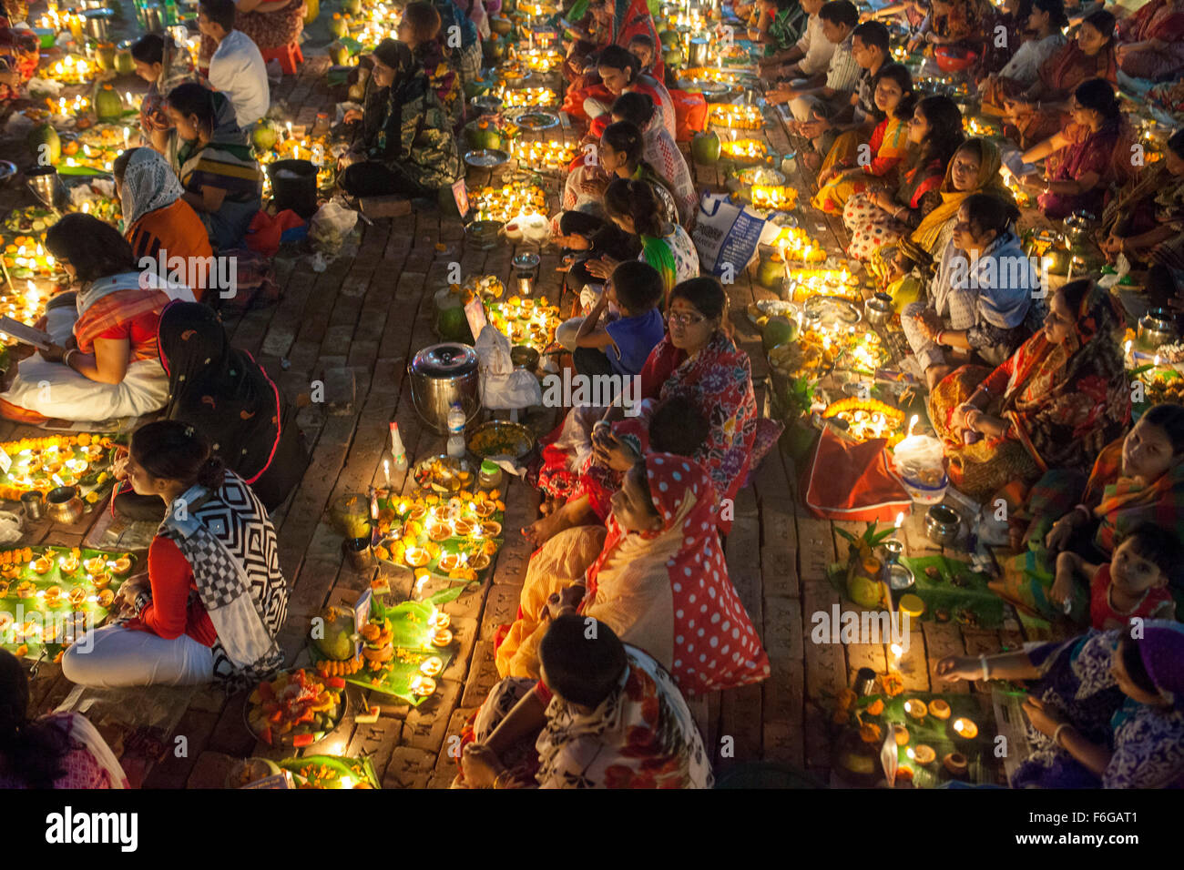 Dacca in Bangladesh. 17 Nov 2015. Migliaia di devoti indù si siede con Prodip e prega Dio di fronte Shri Shri Lokanath Brahmachari Ashram tempio durante il Kartik Brati o Rakher Upobash Dhaka il 17 novembre 2015. Ogni anno migliaia di devoti indù si riuniscono di fronte di Shri Shri Lokenath Brahmachari Ashram tempio per il Kartik Brati o Rakher Upobash festival religioso in Barodi, vicino a Dacca in Bangladesh. Fedeli di sedersi di fronte luce delle candele ( chiamato localmente come Prodip ) e assorbire nella preghiera...Lokenath Brahmachari chi è chiamato Baba Lokenath era un 18t Foto Stock
