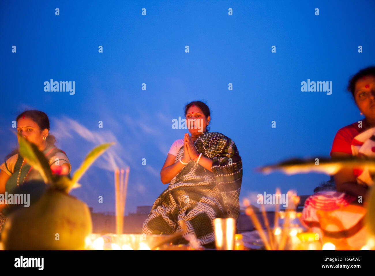 Dacca in Bangladesh. 17 Nov 2015. Migliaia di devoti indù si siede con Prodip e prega Dio di fronte Shri Shri Lokanath Brahmachari Ashram tempio durante il Kartik Brati o Rakher Upobash Dhaka il 17 novembre 2015. Ogni anno migliaia di devoti indù si riuniscono di fronte di Shri Shri Lokenath Brahmachari Ashram tempio per il Kartik Brati o Rakher Upobash festival religioso in Barodi, vicino a Dacca in Bangladesh. Fedeli di sedersi di fronte luce delle candele ( chiamato localmente come Prodip ) e assorbire nella preghiera...Lokenath Brahmachari chi è chiamato Baba Lokenath era un 18t Foto Stock