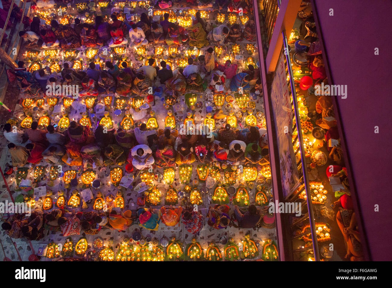 Dacca in Bangladesh. 17 Nov 2015. Migliaia di devoti indù si siede con Prodip e prega Dio di fronte Shri Shri Lokanath Brahmachari Ashram tempio durante il Kartik Brati o Rakher Upobash Dhaka il 17 novembre 2015. Ogni anno migliaia di devoti indù si riuniscono di fronte di Shri Shri Lokenath Brahmachari Ashram tempio per il Kartik Brati o Rakher Upobash festival religioso in Barodi, vicino a Dacca in Bangladesh. Fedeli di sedersi di fronte luce delle candele ( chiamato localmente come Prodip ) e assorbire nella preghiera...Lokenath Brahmachari chi è chiamato Baba Lokenath era un 18t Foto Stock