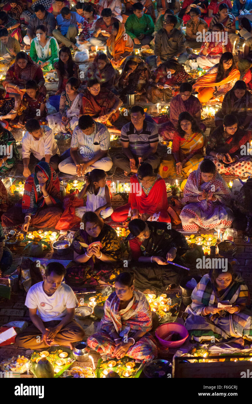 Dacca in Bangladesh. 17 Nov 2015. Migliaia di devoti indù si siede con Prodip e prega Dio di fronte Shri Shri Lokanath Brahmachari Ashram tempio durante il Kartik Brati o Rakher Upobash Dhaka il 17 novembre 2015. Ogni anno migliaia di devoti indù si riuniscono di fronte di Shri Shri Lokenath Brahmachari Ashram tempio per il Kartik Brati o Rakher Upobash festival religioso in Barodi, vicino a Dacca in Bangladesh. Fedeli di sedersi di fronte luce delle candele ( chiamato localmente come Prodip ) e assorbire nella preghiera...Lokenath Brahmachari chi è chiamato Baba Lokenath era un 18t Foto Stock