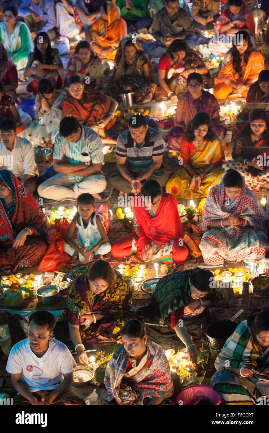 Dacca in Bangladesh. 17 Nov 2015. Migliaia di devoti indù si siede con Prodip e prega Dio di fronte Shri Shri Lokanath Brahmachari Ashram tempio durante il Kartik Brati o Rakher Upobash Dhaka il 17 novembre 2015. Ogni anno migliaia di devoti indù si riuniscono di fronte di Shri Shri Lokenath Brahmachari Ashram tempio per il Kartik Brati o Rakher Upobash festival religioso in Barodi, vicino a Dacca in Bangladesh. Fedeli di sedersi di fronte luce delle candele ( chiamato localmente come Prodip ) e assorbire nella preghiera...Lokenath Brahmachari chi è chiamato Baba Lokenath era un 18t Foto Stock