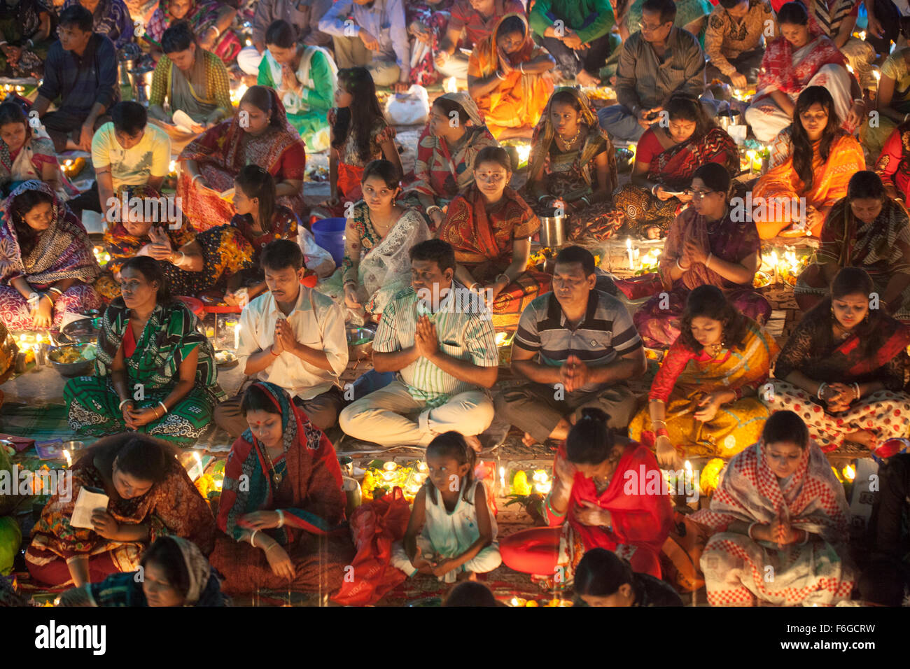 Dacca in Bangladesh. 17 Nov 2015. Migliaia di devoti indù si siede con Prodip e prega Dio di fronte Shri Shri Lokanath Brahmachari Ashram tempio durante il Kartik Brati o Rakher Upobash Dhaka il 17 novembre 2015. Ogni anno migliaia di devoti indù si riuniscono di fronte di Shri Shri Lokenath Brahmachari Ashram tempio per il Kartik Brati o Rakher Upobash festival religioso in Barodi, vicino a Dacca in Bangladesh. Fedeli di sedersi di fronte luce delle candele ( chiamato localmente come Prodip ) e assorbire nella preghiera...Lokenath Brahmachari chi è chiamato Baba Lokenath era un 18t Foto Stock