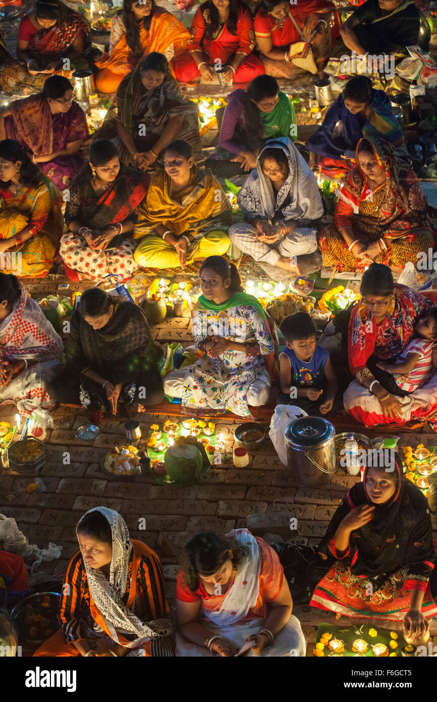 Dacca in Bangladesh. 17 Nov 2015. Migliaia di devoti indù si siede con Prodip e prega Dio di fronte Shri Shri Lokanath Brahmachari Ashram tempio durante il Kartik Brati o Rakher Upobash Dhaka il 17 novembre 2015. Ogni anno migliaia di devoti indù si riuniscono di fronte di Shri Shri Lokenath Brahmachari Ashram tempio per il Kartik Brati o Rakher Upobash festival religioso in Barodi, vicino a Dacca in Bangladesh. Fedeli di sedersi di fronte luce delle candele ( chiamato localmente come Prodip ) e assorbire nella preghiera...Lokenath Brahmachari chi è chiamato Baba Lokenath era un 18t Foto Stock