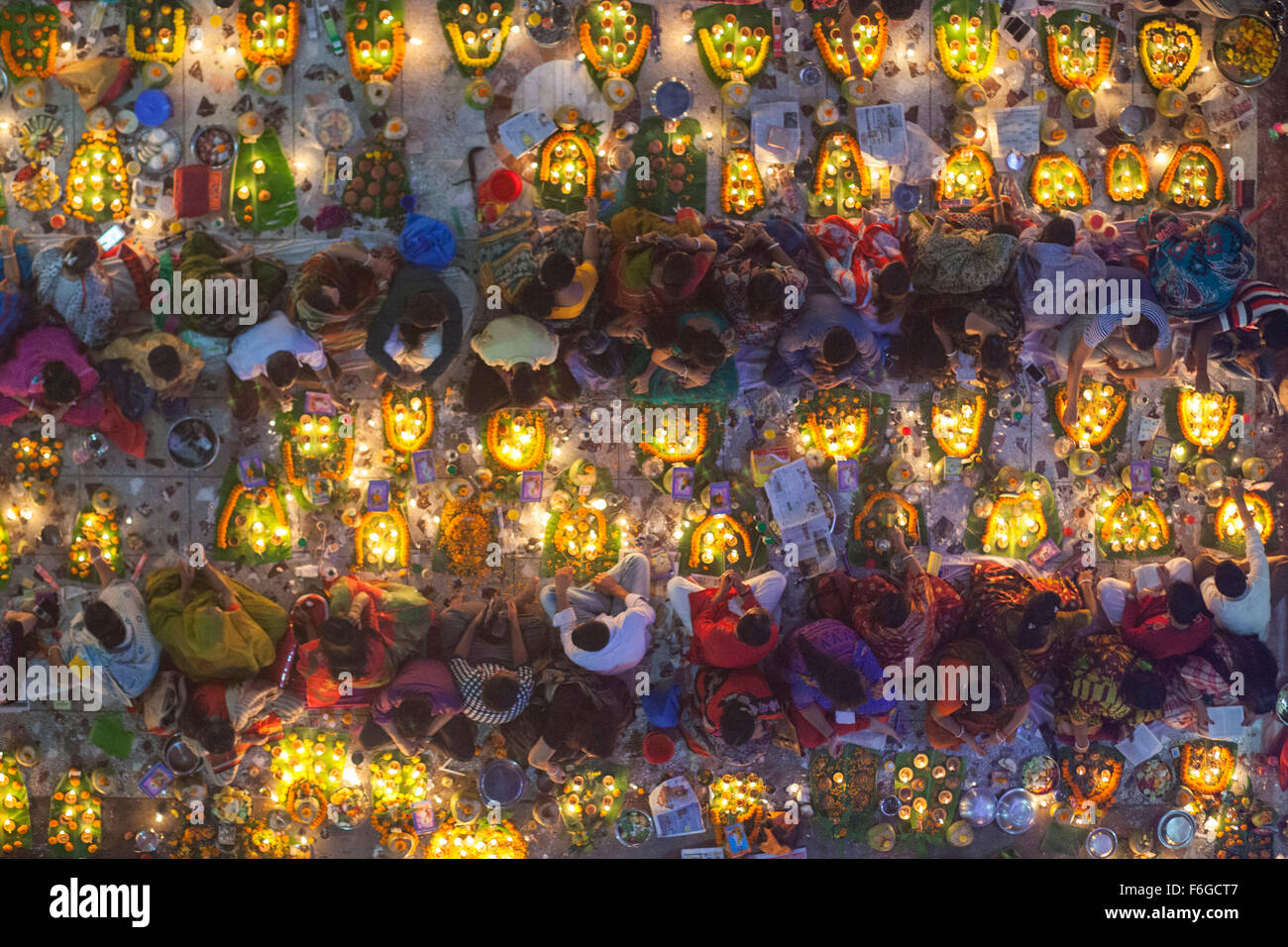 Dacca in Bangladesh. 17 Nov 2015. Migliaia di devoti indù si siede con Prodip e prega Dio di fronte Shri Shri Lokanath Brahmachari Ashram tempio durante il Kartik Brati o Rakher Upobash Dhaka il 17 novembre 2015. Ogni anno migliaia di devoti indù si riuniscono di fronte di Shri Shri Lokenath Brahmachari Ashram tempio per il Kartik Brati o Rakher Upobash festival religioso in Barodi, vicino a Dacca in Bangladesh. Fedeli di sedersi di fronte luce delle candele ( chiamato localmente come Prodip ) e assorbire nella preghiera...Lokenath Brahmachari chi è chiamato Baba Lokenath era un 18t Foto Stock