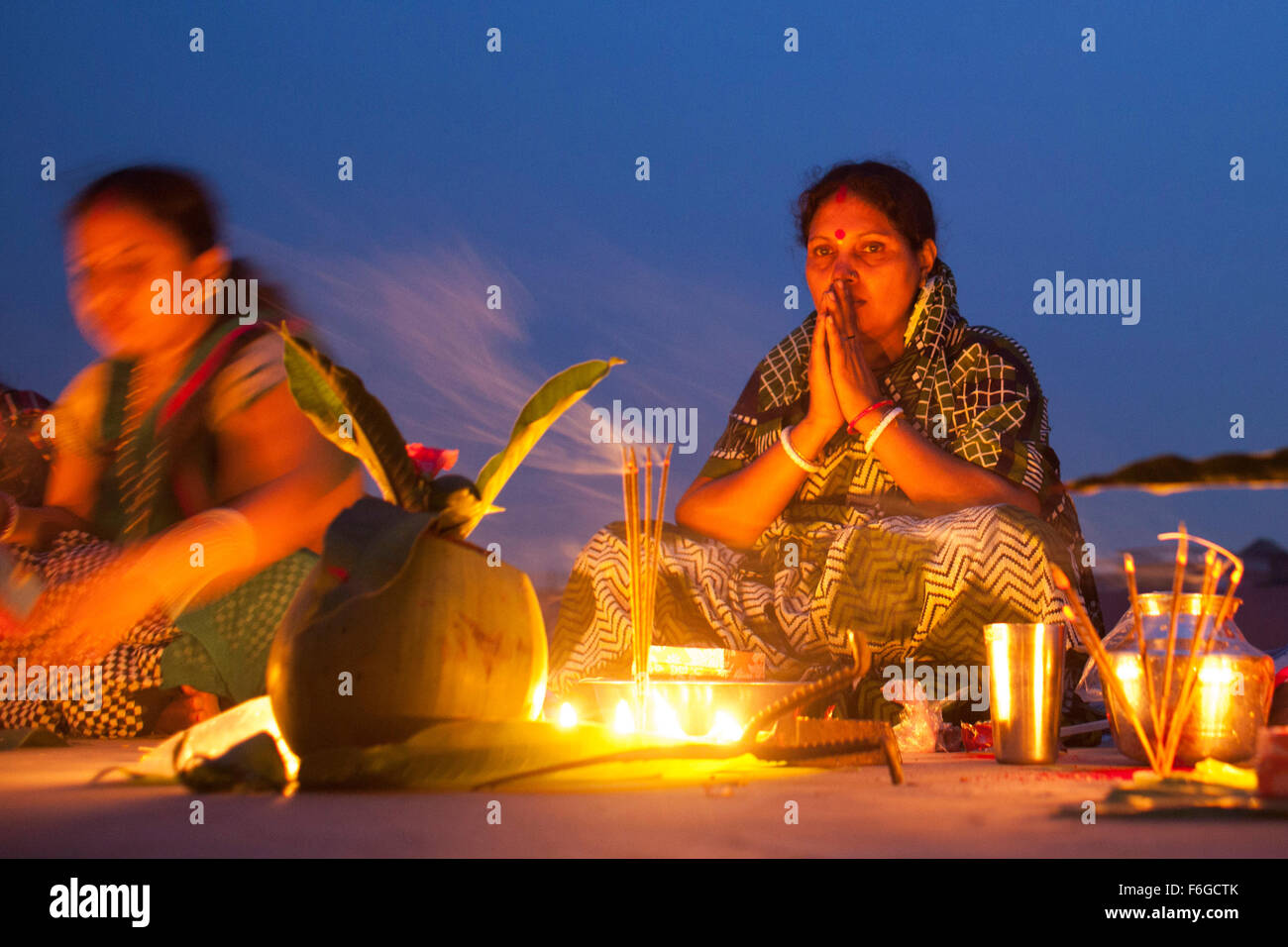 Dacca in Bangladesh. 17 Nov 2015. Migliaia di devoti indù si siede con Prodip e prega Dio di fronte Shri Shri Lokanath Brahmachari Ashram tempio durante il Kartik Brati o Rakher Upobash Dhaka il 17 novembre 2015. Ogni anno migliaia di devoti indù si riuniscono di fronte di Shri Shri Lokenath Brahmachari Ashram tempio per il Kartik Brati o Rakher Upobash festival religioso in Barodi, vicino a Dacca in Bangladesh. Fedeli di sedersi di fronte luce delle candele ( chiamato localmente come Prodip ) e assorbire nella preghiera...Lokenath Brahmachari chi è chiamato Baba Lokenath era un 18t Foto Stock