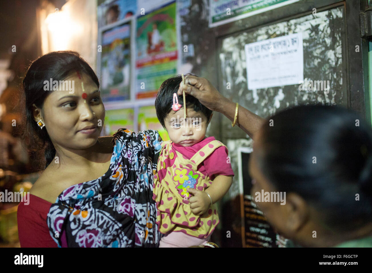 Dacca in Bangladesh. 17 Nov 2015. Migliaia di devoti indù si siede con Prodip e prega Dio di fronte Shri Shri Lokanath Brahmachari Ashram tempio durante il Kartik Brati o Rakher Upobash Dhaka il 17 novembre 2015. Ogni anno migliaia di devoti indù si riuniscono di fronte di Shri Shri Lokenath Brahmachari Ashram tempio per il Kartik Brati o Rakher Upobash festival religioso in Barodi, vicino a Dacca in Bangladesh. Fedeli di sedersi di fronte luce delle candele ( chiamato localmente come Prodip ) e assorbire nella preghiera...Lokenath Brahmachari chi è chiamato Baba Lokenath era un 18t Foto Stock