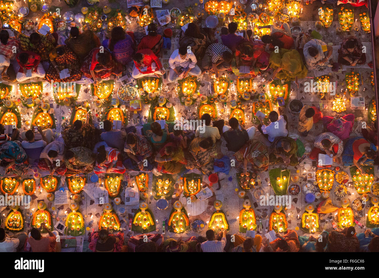 Dacca in Bangladesh. 17 Nov 2015. Migliaia di devoti indù si siede con Prodip e prega Dio di fronte Shri Shri Lokanath Brahmachari Ashram tempio durante il Kartik Brati o Rakher Upobash Dhaka il 17 novembre 2015. Ogni anno migliaia di devoti indù si riuniscono di fronte di Shri Shri Lokenath Brahmachari Ashram tempio per il Kartik Brati o Rakher Upobash festival religioso in Barodi, vicino a Dacca in Bangladesh. Fedeli di sedersi di fronte luce delle candele ( chiamato localmente come Prodip ) e assorbire nella preghiera...Lokenath Brahmachari chi è chiamato Baba Lokenath era un 18t Foto Stock
