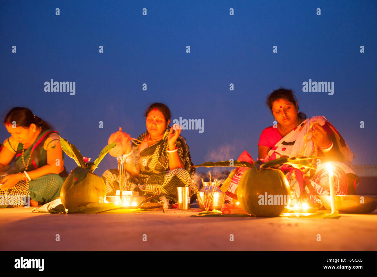 Dacca in Bangladesh. 17 Nov 2015. Migliaia di devoti indù si siede con Prodip e prega Dio di fronte Shri Shri Lokanath Brahmachari Ashram tempio durante il Kartik Brati o Rakher Upobash Dhaka il 17 novembre 2015. Ogni anno migliaia di devoti indù si riuniscono di fronte di Shri Shri Lokenath Brahmachari Ashram tempio per il Kartik Brati o Rakher Upobash festival religioso in Barodi, vicino a Dacca in Bangladesh. Fedeli di sedersi di fronte luce delle candele ( chiamato localmente come Prodip ) e assorbire nella preghiera...Lokenath Brahmachari chi è chiamato Baba Lokenath era un 18t Foto Stock