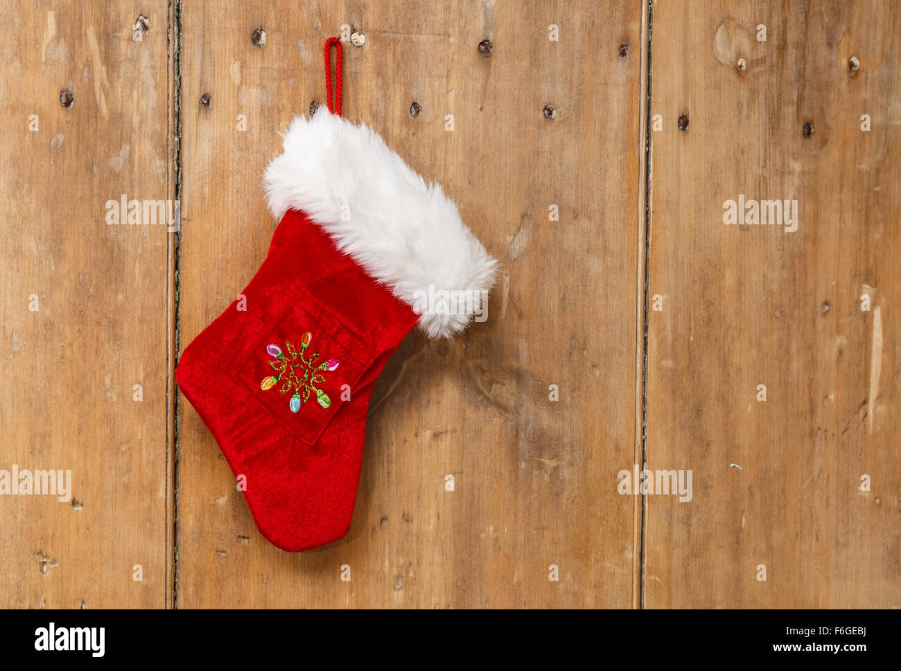 Calza di Natale appeso su un vecchio pino porta in legno Foto Stock