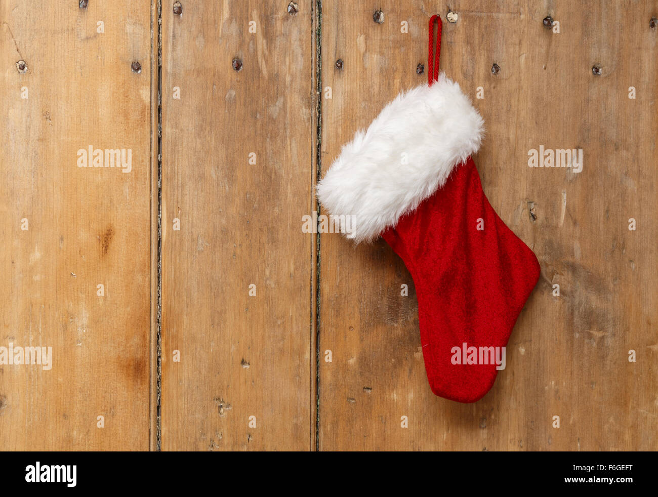 Calza di Natale appeso su un vecchio pino porta in legno Foto Stock